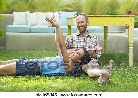 Stock Photograph - Couple relaxing in backyard. Fotosearch