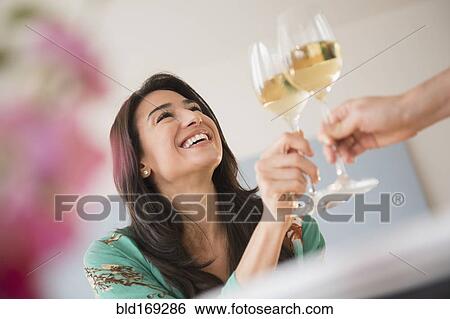 Stock Photograph - Couple toasting with glasses of white wine. Fotosearch