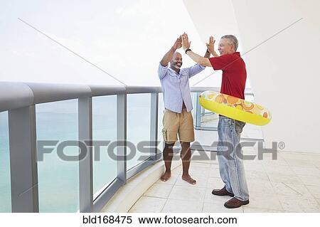 Stock Photography - Father and son cheering in inflatable ring. Fotosearch