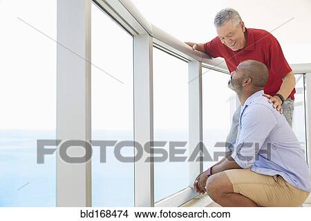 Picture - Father and son standing on balcony. Fotosearch