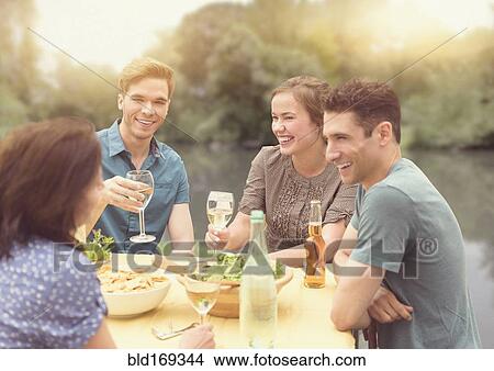Friends having dinner party in backyard View Large Photo Image Picture - Friends having dinner party in backyard. Fotosearch