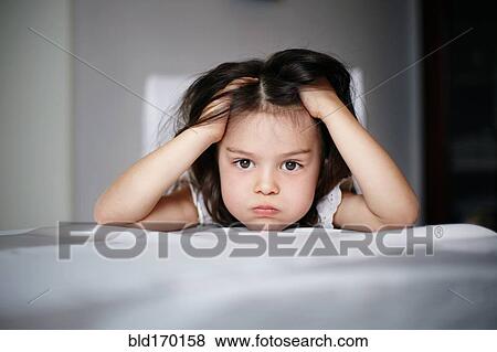 Stock Photo - Frustrated Caucasian girl laying on bed. Fotosearch