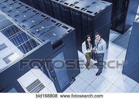 Stock Photo - High angle view of technicians smiling in server room. Fotosearch