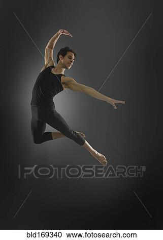 Stock Image - Hispanic ballet dancer leaping in mid-air. Fotosearch