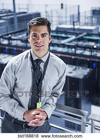 Stock Photo - Hispanic businessman standing on balcony over server room. Fotosearch