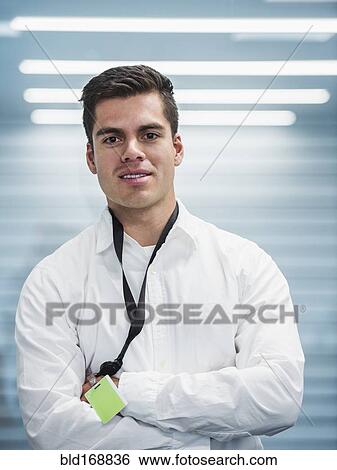 Hispanic businessman standing with arms folded in office View Large Photo Image Stock Photograph - Hispanic businessman standing with arms folded in office. Fotosearch