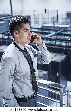 Hispanic businessman talking on cell phone on balcony over server room View Large Photo Image Stock Image - Hispanic businessman talking on cell phone on balcony over server room. Fotosearch