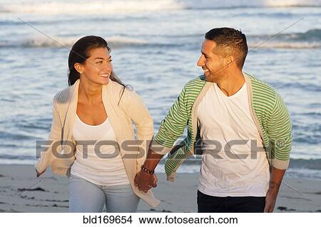 Hispanic couple holding hands on beach View Large Photo Image Picture - Hispanic couple holding hands on beach. Fotosearch