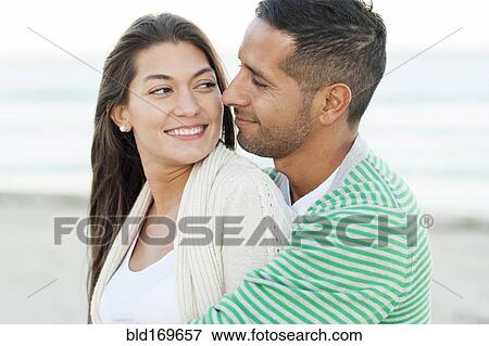 Hispanic couple hugging on beach View Large Photo Image Stock Photo - Hispanic couple hugging on beach. Fotosearch