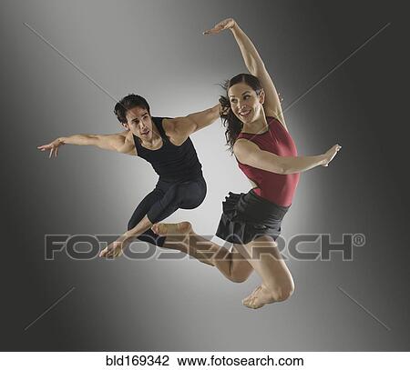 Stock Image - Hispanic dancers leaping in mid-air. Fotosearch