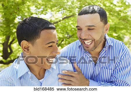 Stock Photography - Hispanic father and son laughing in park. Fotosearch