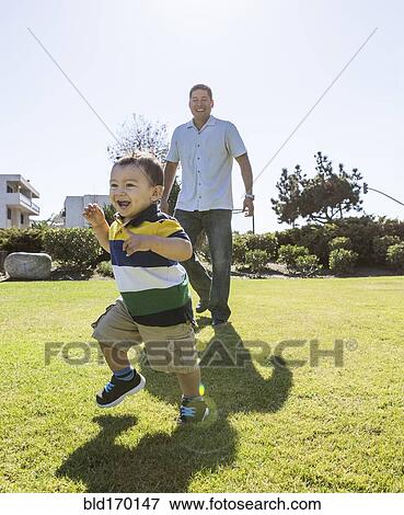 Hispanic father and son playing in park View Large Photo Image Stock Photo - Hispanic father and son playing in park. Fotosearch