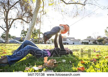 Hispanic mother playing with son in park View Large Photo Image Stock Photo - Hispanic mother playing with son in park. Fotosearch