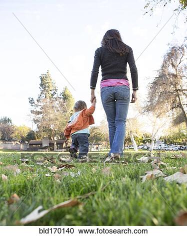 Hispanic mother walking with son in park View Large Photo Image Stock Image - Hispanic mother walking with son in park. Fotosearch