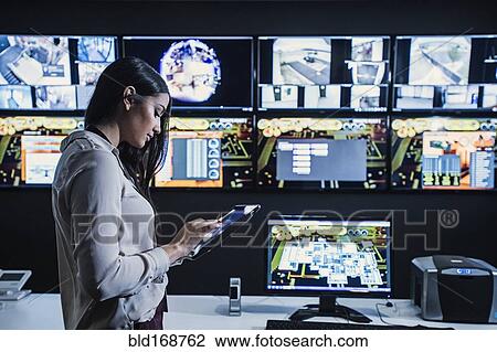 Hispanic security guard using digital tablet in control room View Large Photo Image Stock Image - Hispanic security guard using digital tablet in control room. Fotosearch