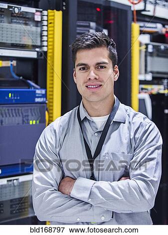 Stock Photo - Hispanic technician smiling in server room. Fotosearch
