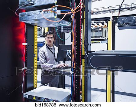 Hispanic technician using computer in server room View Large Photo Image Stock Photo - Hispanic technician using computer in server room. Fotosearch
