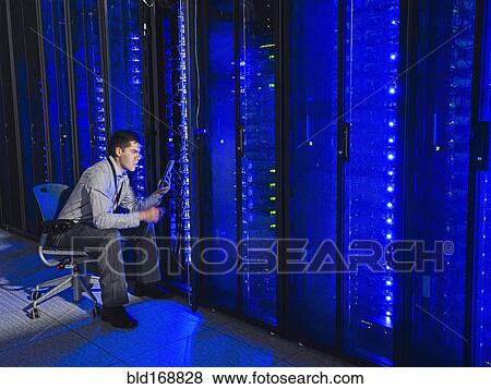 Hispanic technician working in server room View Large Photo Image Stock Photo - Hispanic technician working in server room. Fotosearch