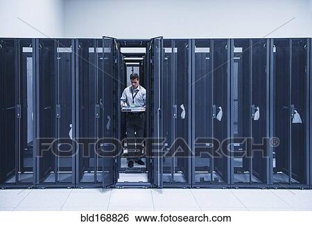 Stock Photograph - Hispanic technician working in server room. Fotosearch