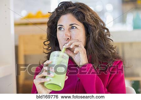 Hispanic woman drinking green juice View Large Photo Image Stock Photograph - Hispanic woman drinking green juice. Fotosearch