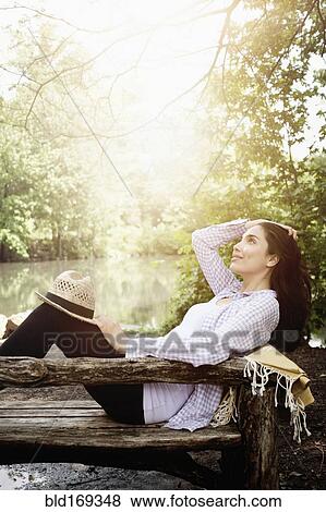 Hispanic woman laying on bench in park View Large Photo Image Stock Photo - Hispanic woman laying on bench in park. Fotosearch