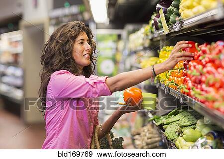 Hispanic woman shopping at grocery store View Large Photo Image Stock Photo - Hispanic woman shopping at grocery store. Fotosearch