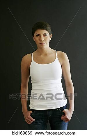 Stock Photo - Hispanic woman standing with thumbs in pockets. Fotosearch