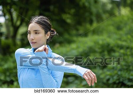 Hispanic woman stretching in park View Large Photo Image Stock Image - Hispanic woman stretching in park. Fotosearch