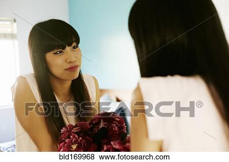 Stock Photo - Japanese woman admiring herself in mirror. Fotosearch