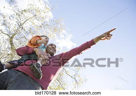 Low angle view of Hispanic father and son pointing outdoors View Large Photo Image Stock Photo - Low angle view of Hispanic father and son pointing outdoors. Fotosearch