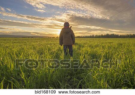 Mari boy admiring sunset in rural field View Large Photo Image Stock Photo - Mari boy admiring sunset in rural field. Fotosearch