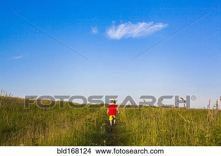 Picture - Mari boy walking in rural field. Fotosearch