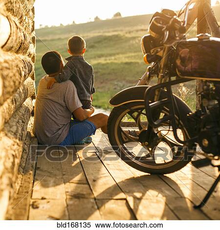 Stock Photography - Mari father and son sitting on patio. Fotosearch