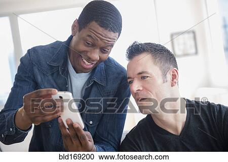 Men reading cell phone in office View Large Photo Image Stock Image - Men reading cell phone in office. Fotosearch