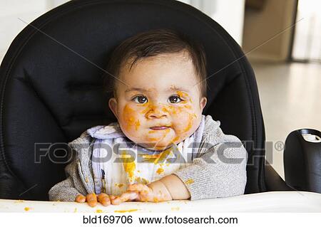 Messy Mixed race baby eating food in high chair View Large Photo Image Stock Photograph - Messy Mixed race baby eating food in high chair. Fotosearch