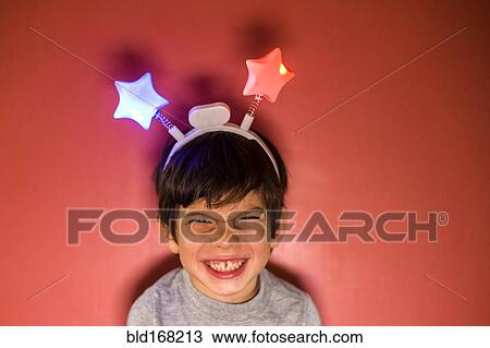 Stock Image - Mixed race boy wearing headband with stars. Fotosearch