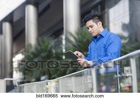 Mixed race businessman using digital tablet outdoors View Large Photo Image Stock Photography - Mixed race businessman using digital tablet outdoors. Fotosearch