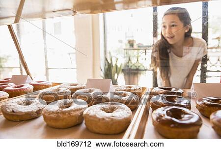 Mixed race girl examining donuts in bakery View Large Photo Image Stock Image - Mixed race girl examining donuts in bakery. Fotosearch