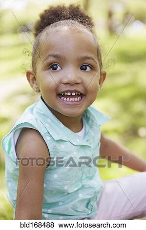 Stock Photo - Mixed race girl smiling in park. Fotosearch