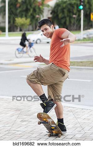 Mixed race man doing trick on skateboard View Large Photo Image Stock Image - Mixed race man doing trick on skateboard. Fotosearch