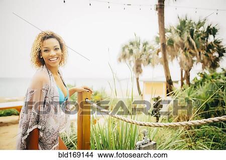 Picture - Mixed race teenager walking on beach. Fotosearch
