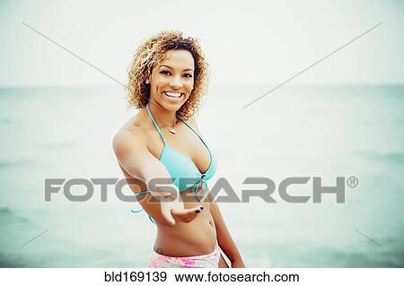 Stock Photo - Mixed race teenager wearing bikini on beach. Fotosearch