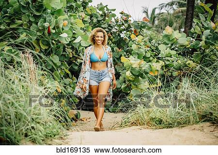 Stock Photography - Mixed race teenager wearing bikini on beach. Fotosearch