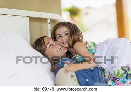 Mother and daughter hugging on bed View Large Photo Image Stock Photo - Mother and daughter hugging on bed. Fotosearch