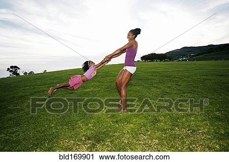 Mother and daughter playing in park View Large Photo Image Stock Image - Mother and daughter playing in park. Fotosearch