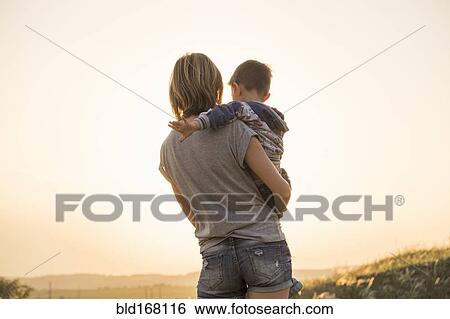 Stock Photograph - Mother holding son in rural field. Fotosearch