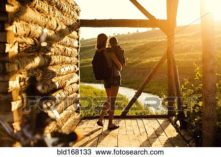Stock Image - Mother holding son on patio. Fotosearch
