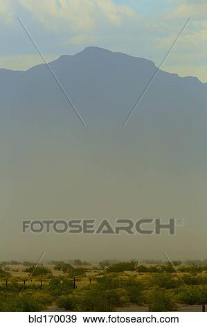 Stock Photo - Mountains over plants growing in arid landscape. Fotosearch