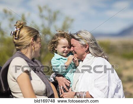 Stock Photo - Multi-generation Caucasian family hugging outdoors. Fotosearch