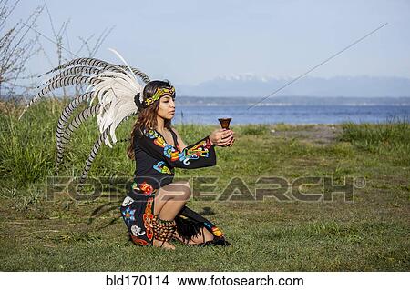Native American woman in traditional headdress performing ceremony View Large Photo Image Picture - Native American woman in traditional headdress performing ceremony. Fotosearch